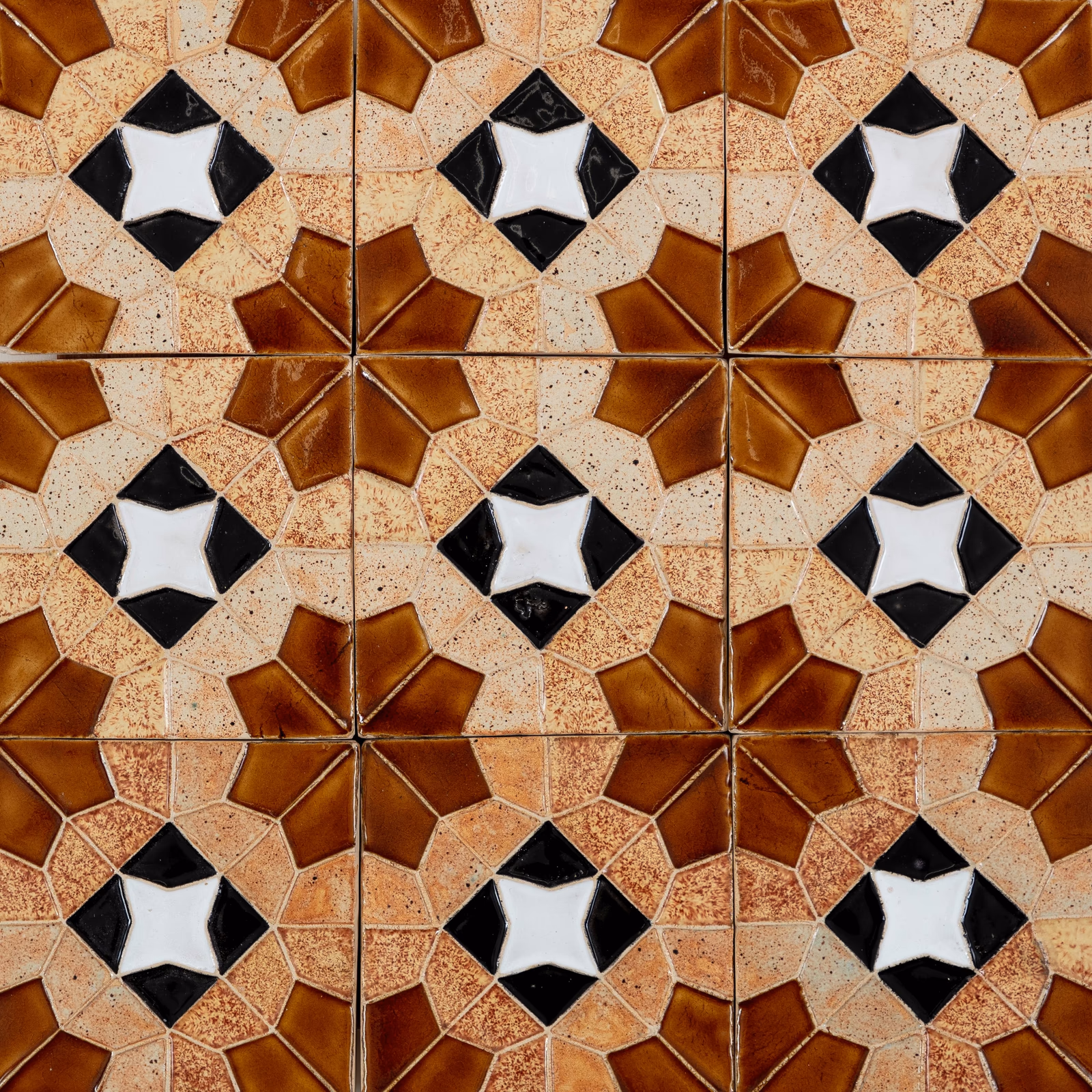 Geometric ceramic tile pattern in brown, cream, black, and white