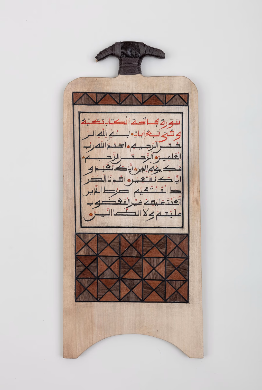 Wooden board with Arabic calligraphy and red geometric pattern